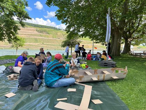Die Kinder basteln Boote aus Pappe